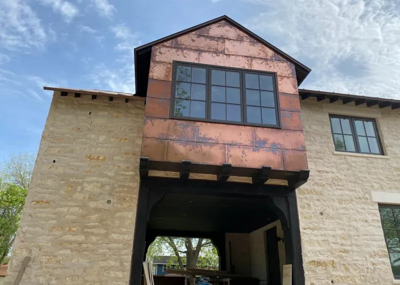 Copper metal panel facade on a stone building for Roof Repair in Prairie Village